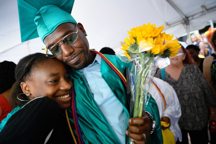 Stephen Corbin gets a congratulatory hug from his niece, Tiandra Prather, 15, after graduating from the Goodwill Excel Center. (Sarah L. Voisin/The 
Washington Post)