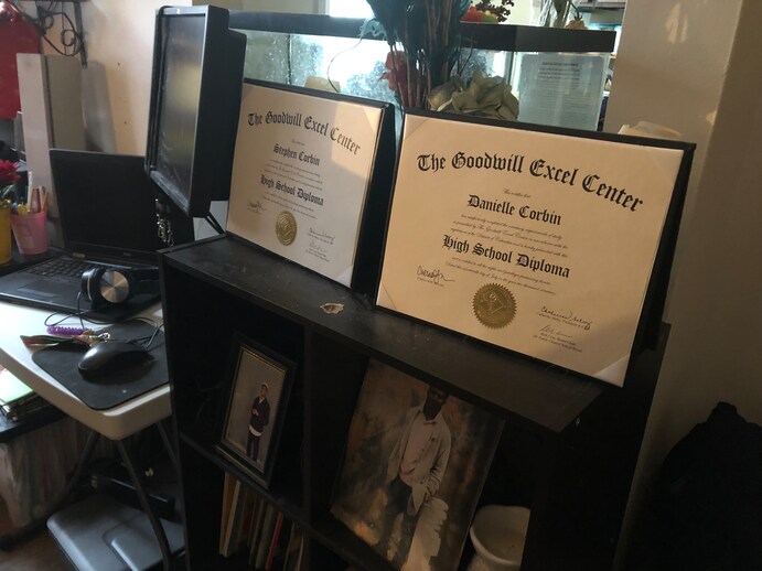 Stephen and Danielle Corbin display their twin diplomas side-by-side on a table in their living room in Washington. Neither thought they would ever graduate from high school. (Hannah Natanson/TWP)
